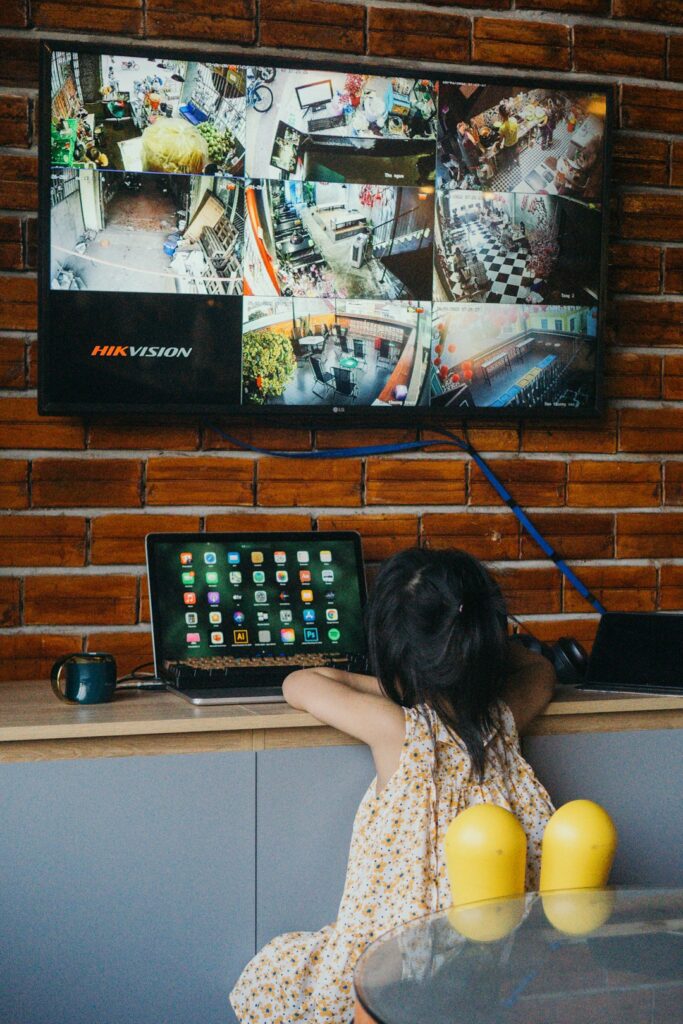 Family watches a television while a router and streaming device sit on a nearby shelf.
